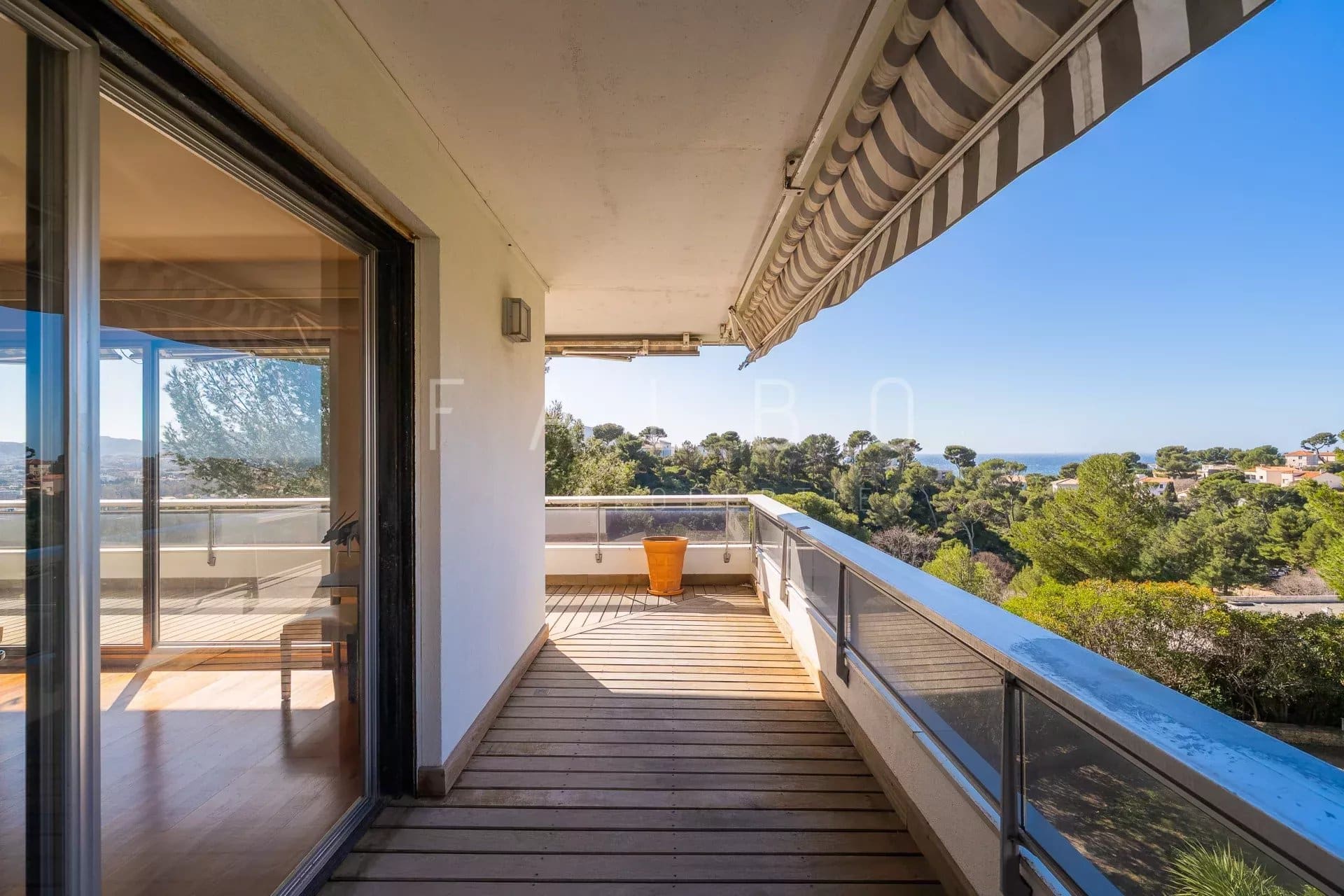 Terrasse d'un appartement avec vue sur la mer à Marseille, entourée de pins.
