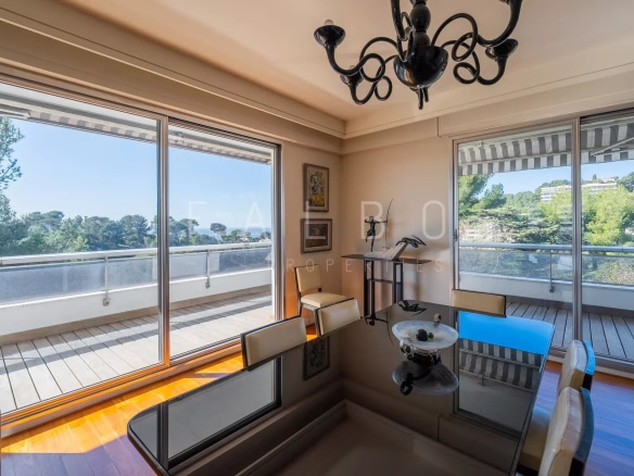 Intérieur d'un appartement avec vue sur mer, grande terrasse et décoration moderne.