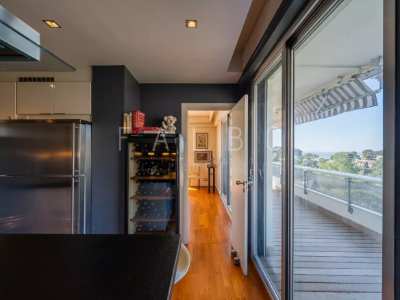 Intérieur d'un appartement avec cuisine ouverte et accès à une terrasse, vue sur la mer à Marseille.