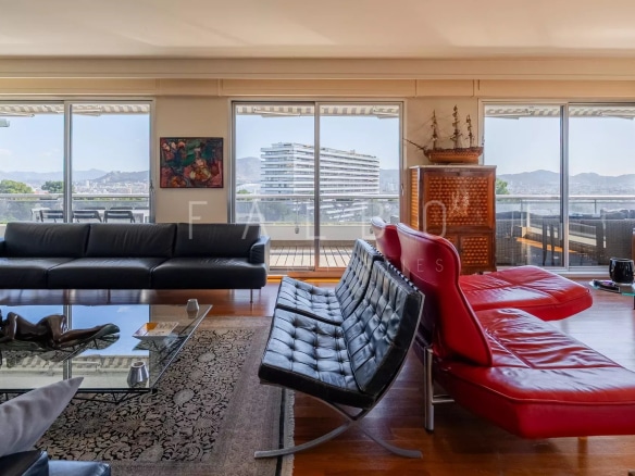 Intérieur d'un appartement spacieux avec vue sur la mer, grande terrasse et mobilier moderne.