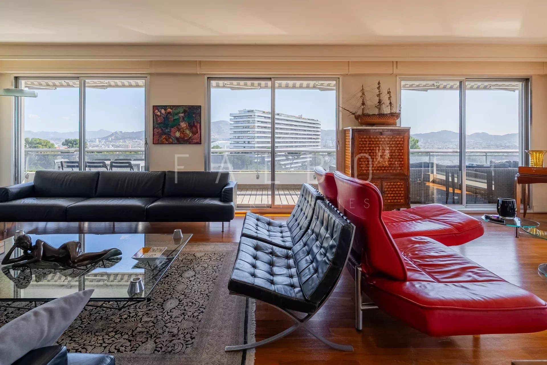 Intérieur d'un appartement spacieux avec vue sur la mer, grande terrasse et mobilier moderne.