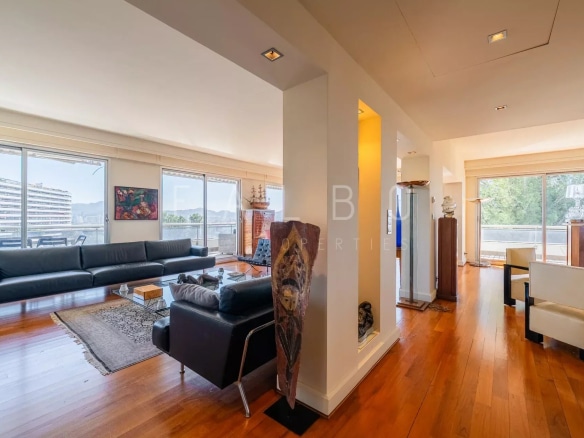 Intérieur d'un appartement spacieux avec vue sur la mer, terrasse et décoration moderne.
