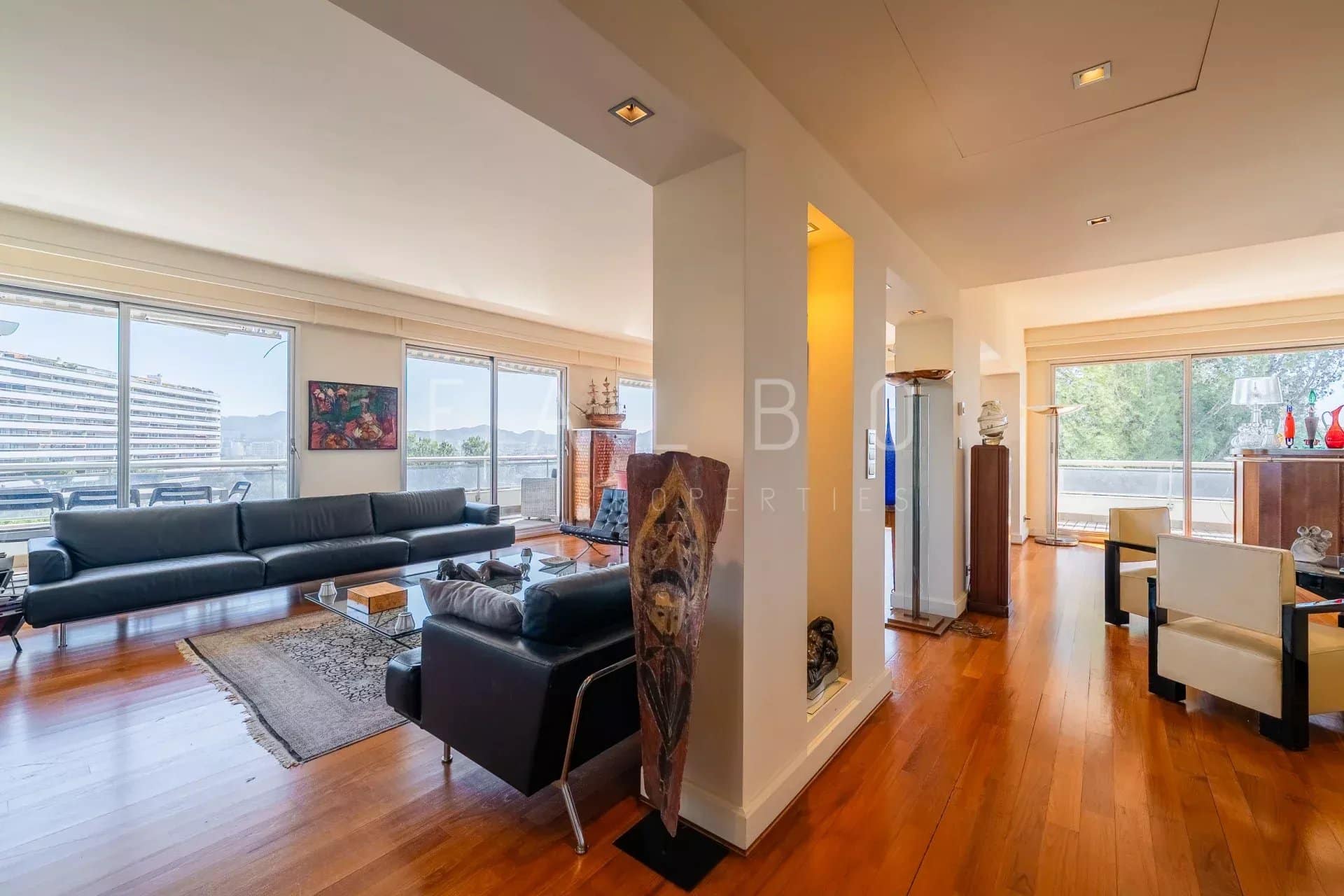 Intérieur d'un appartement spacieux avec vue sur la mer, terrasse et décoration moderne.