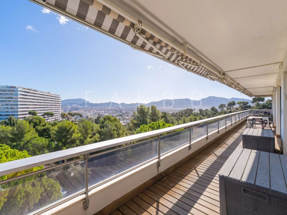 Terrasse d'un appartement avec vue sur la mer à Marseille, entourée de pins.