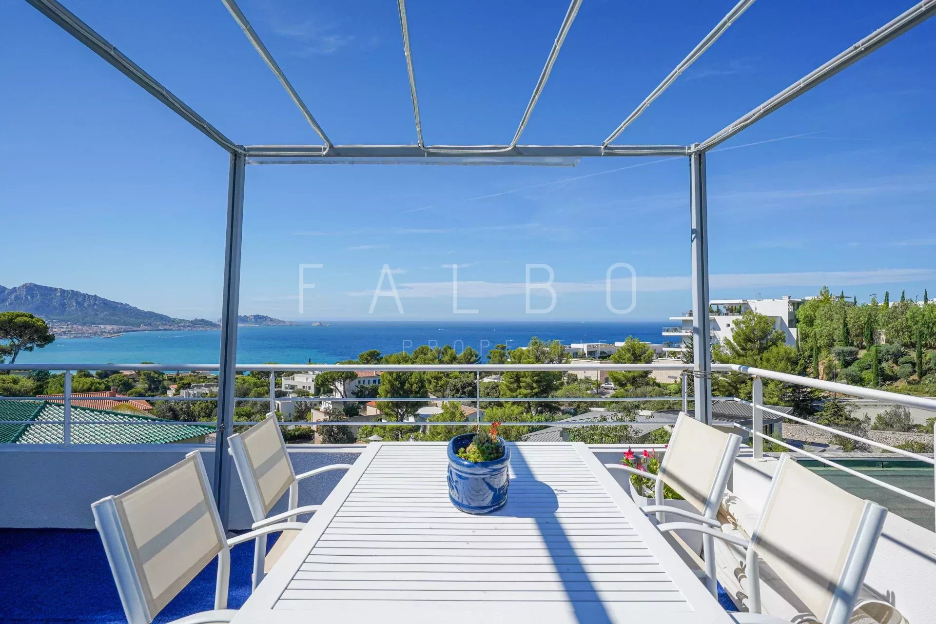 Terrace of a contemporary villa with sea view in Marseille, white outdoor furniture.