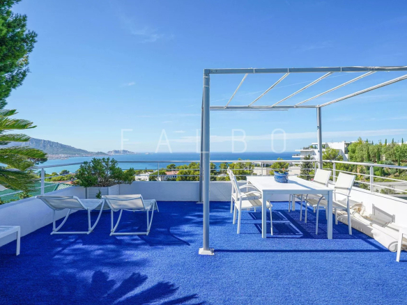 Terrace of a contemporary villa with sea view in Marseille, white outdoor furniture on a blue carpet.