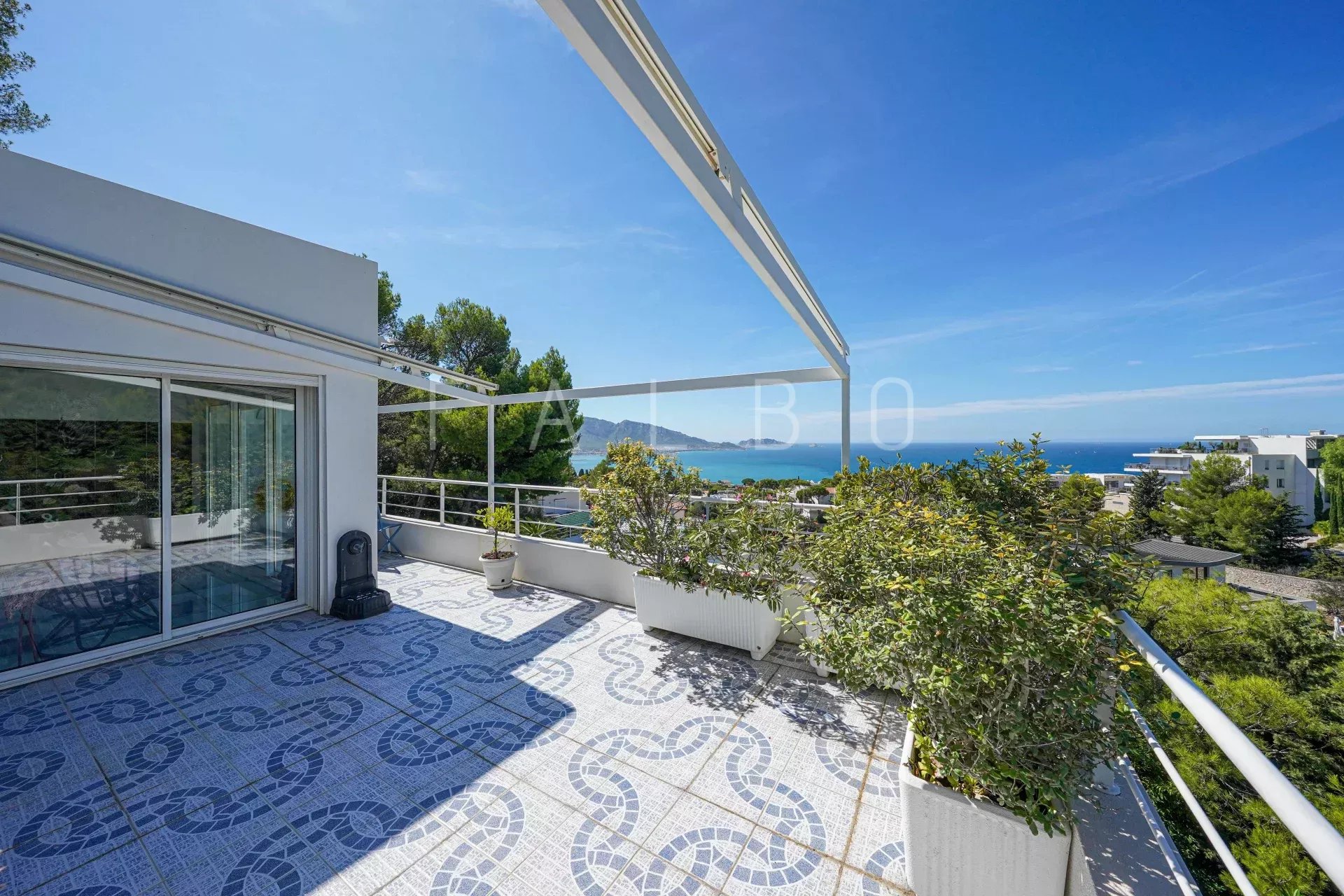 Terrace of a contemporary villa with sea views in Marseille, surrounded by greenery.