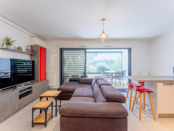 Intérieur d'un appartement Type 3 à La Ciotat avec salon moderne et accès à la terrasse.