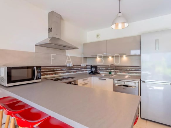 Cuisine moderne d'un appartement Type 3 à La Ciotat avec bar et équipements récents.