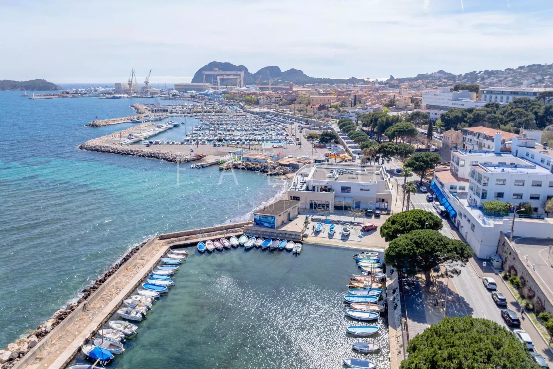 Port de La Ciotat Vue aérienne du port de La Ciotat avec des bateaux et des montagnes en arrière-plan.