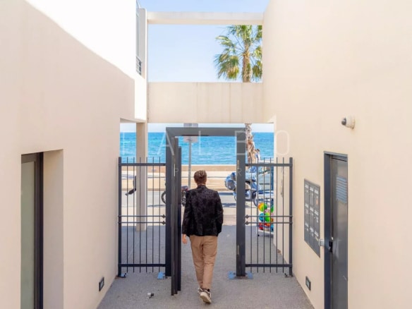 Homme marchant vers une entrée sécurisée avec vue sur la mer à La Ciotat.