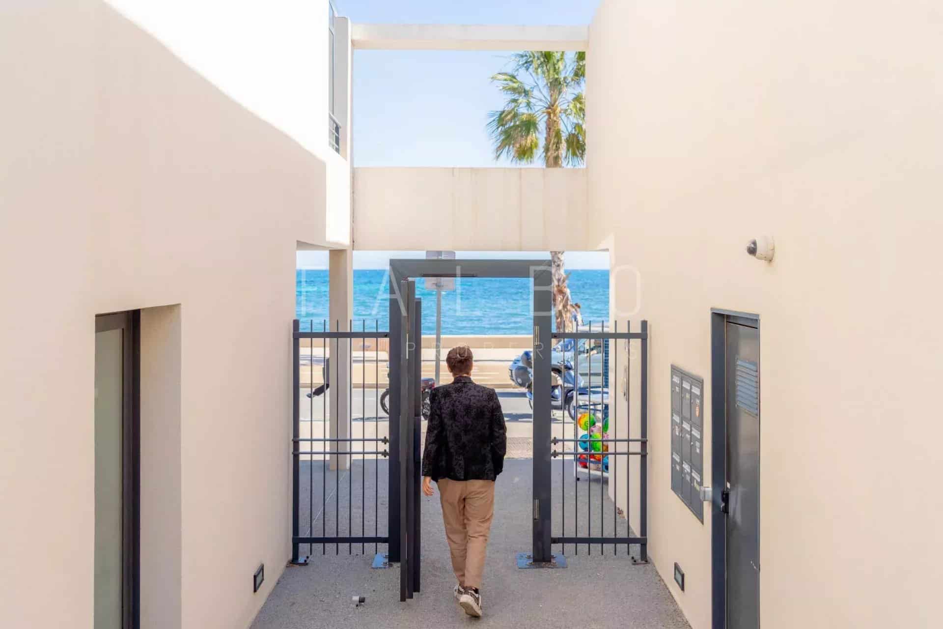 Entrée d’un appartement en front de mer à La Ciotat Homme marchant vers une entrée sécurisée avec vue sur la mer à La Ciotat.