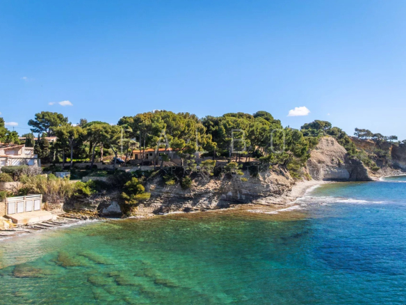 Vue de la mer et des côtes rocheuses à La Ciotat, avec des arbres et des villas en arrière-plan.