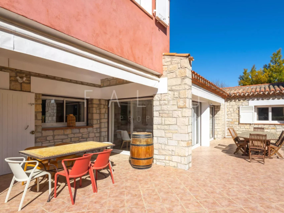 Terrace of a villa with outdoor furniture and a view of a garden in La Ciotat.