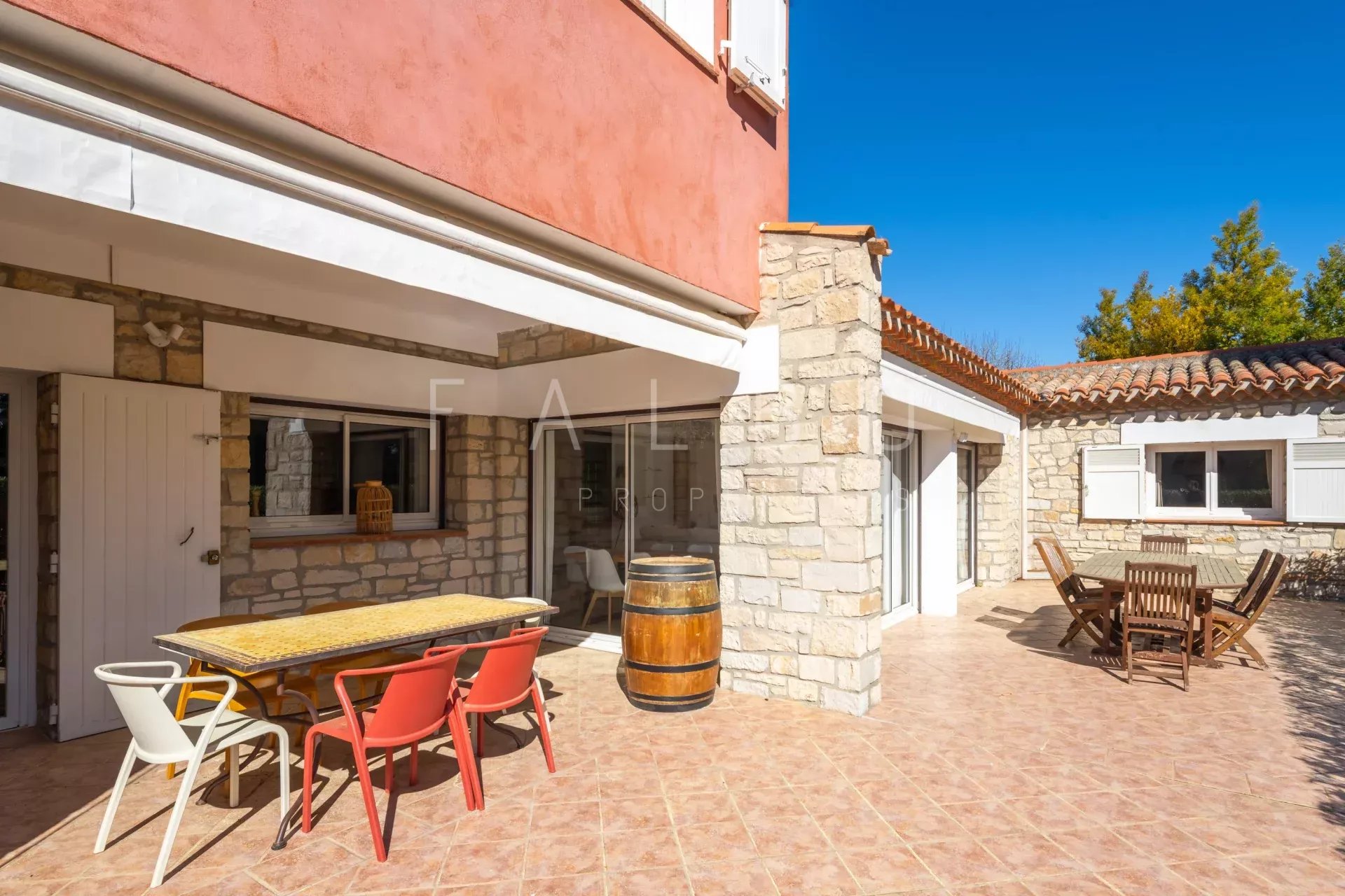 Terrace of a villa with outdoor furniture and a view of a garden in La Ciotat.