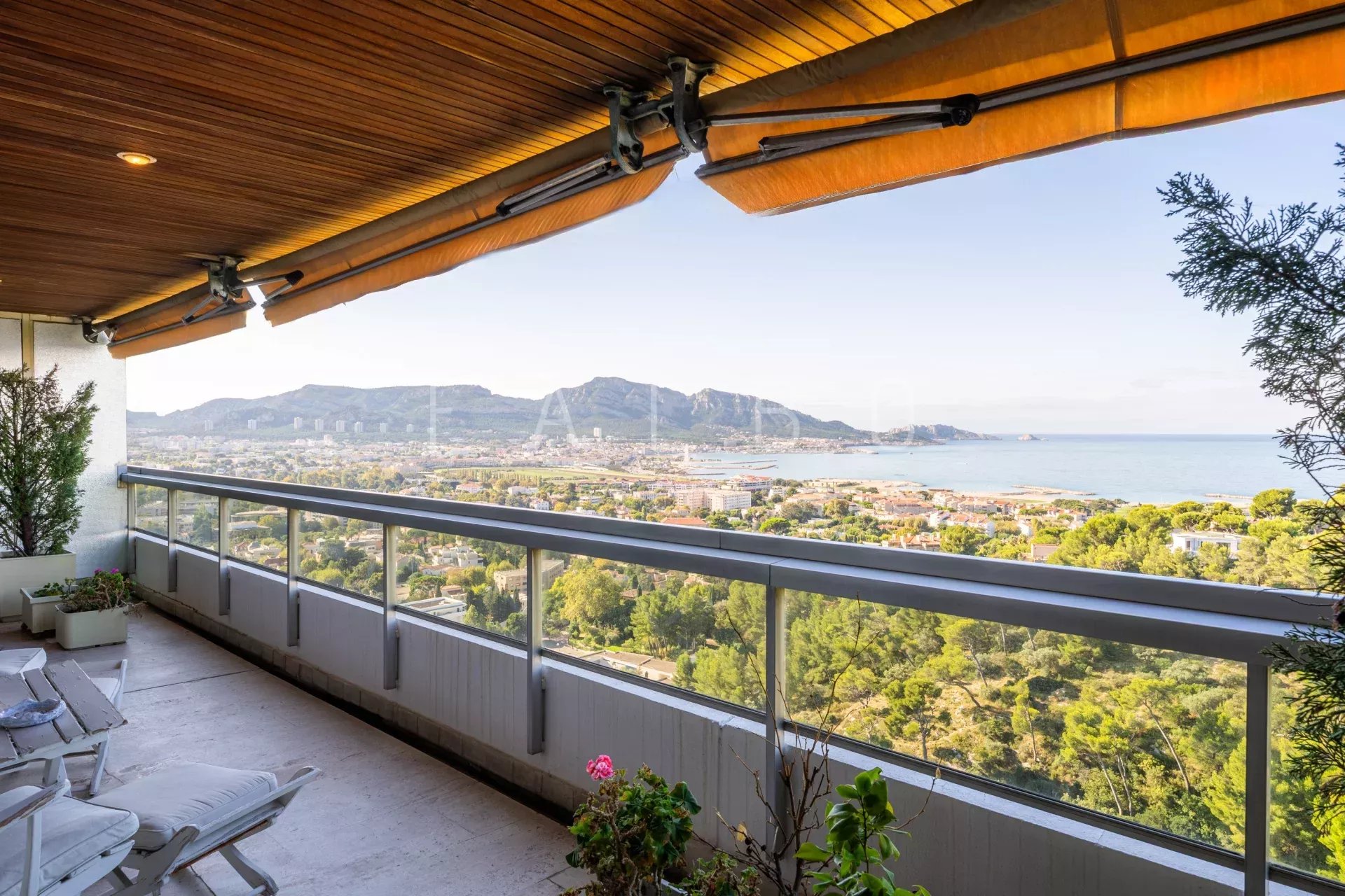 Vue mer depuis le dernier étage à Marseille 8e Vue panoramique sur la mer depuis un toit-terrasse à Marseille 8e, avec des montagnes en arrière-plan.