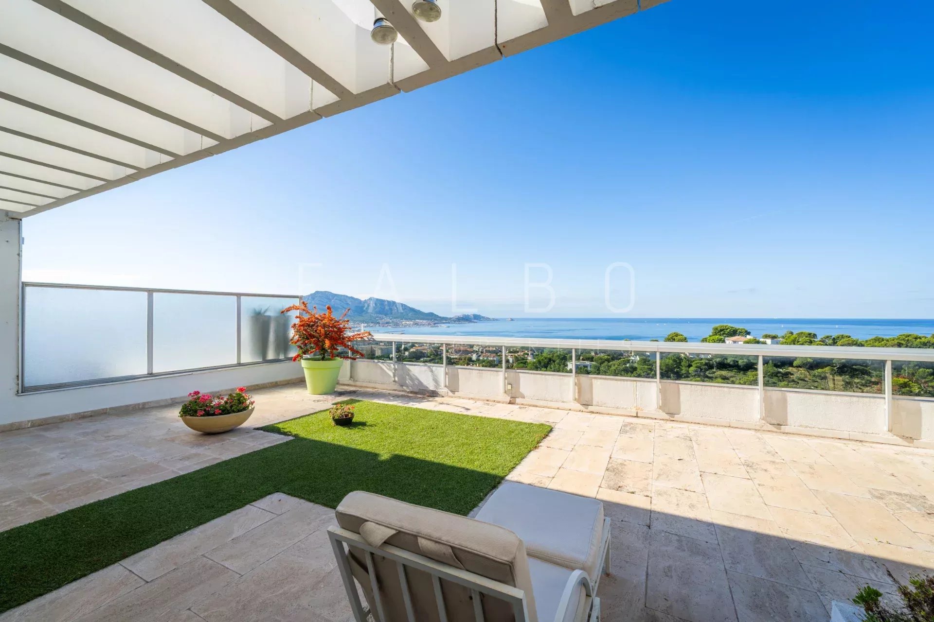 Vue mer depuis le toit-terrasse à Marseille 8e Terrasse avec vue mer panoramique à Marseille, mobilier extérieur et végétation méditerranéenne.