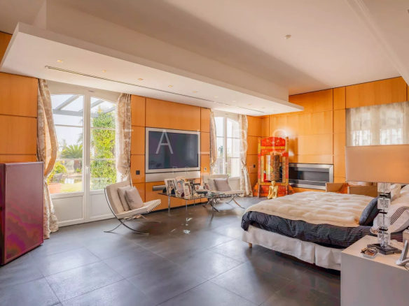 Chambre lumineuse d'une villa contemporaine avec vue sur un parc paysager.