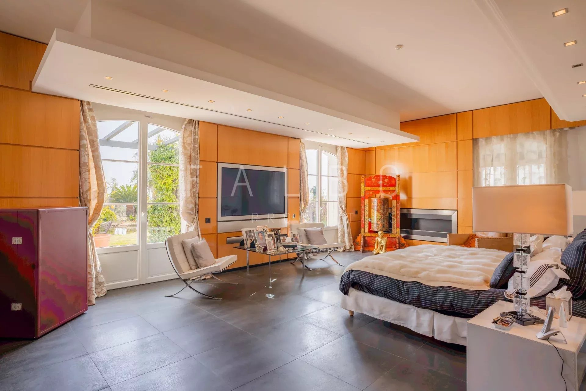 Chambre lumineuse d'une villa contemporaine avec vue sur un parc paysager.