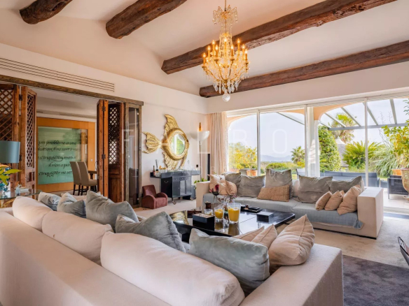 Intérieur d'une villa contemporaine avec vue mer, salon spacieux et décor élégant.