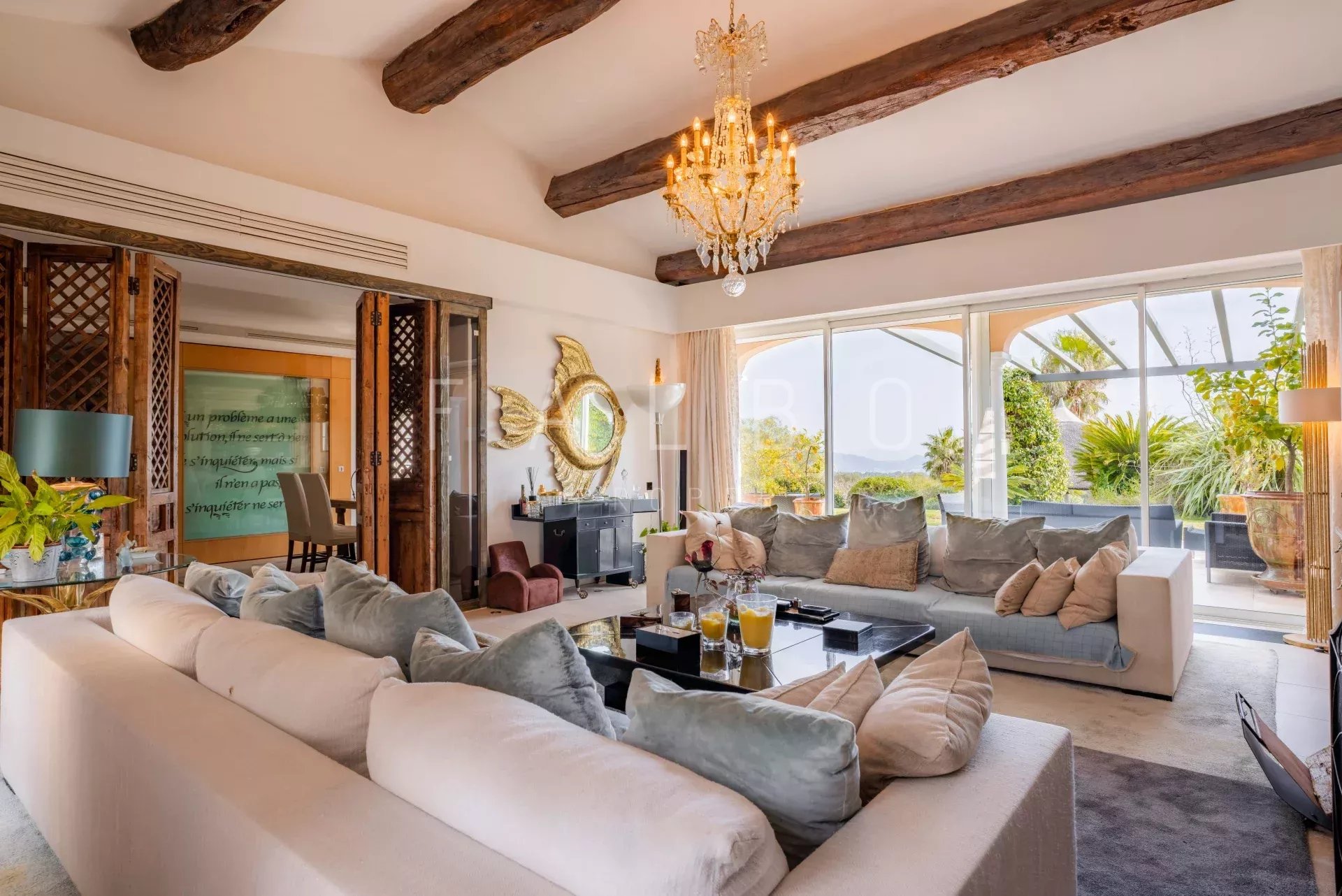 Intérieur d'une villa contemporaine avec vue mer, salon spacieux et décor élégant.