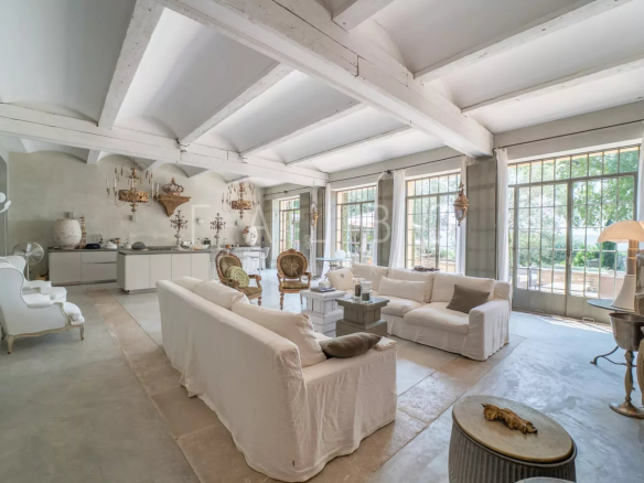 Interior of a stone farmhouse with a large, bright living room and elegant furniture.