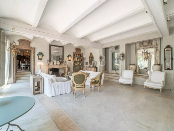 Interior of a renovated Provençal farmhouse with a large, bright living room and elegant decorative elements.