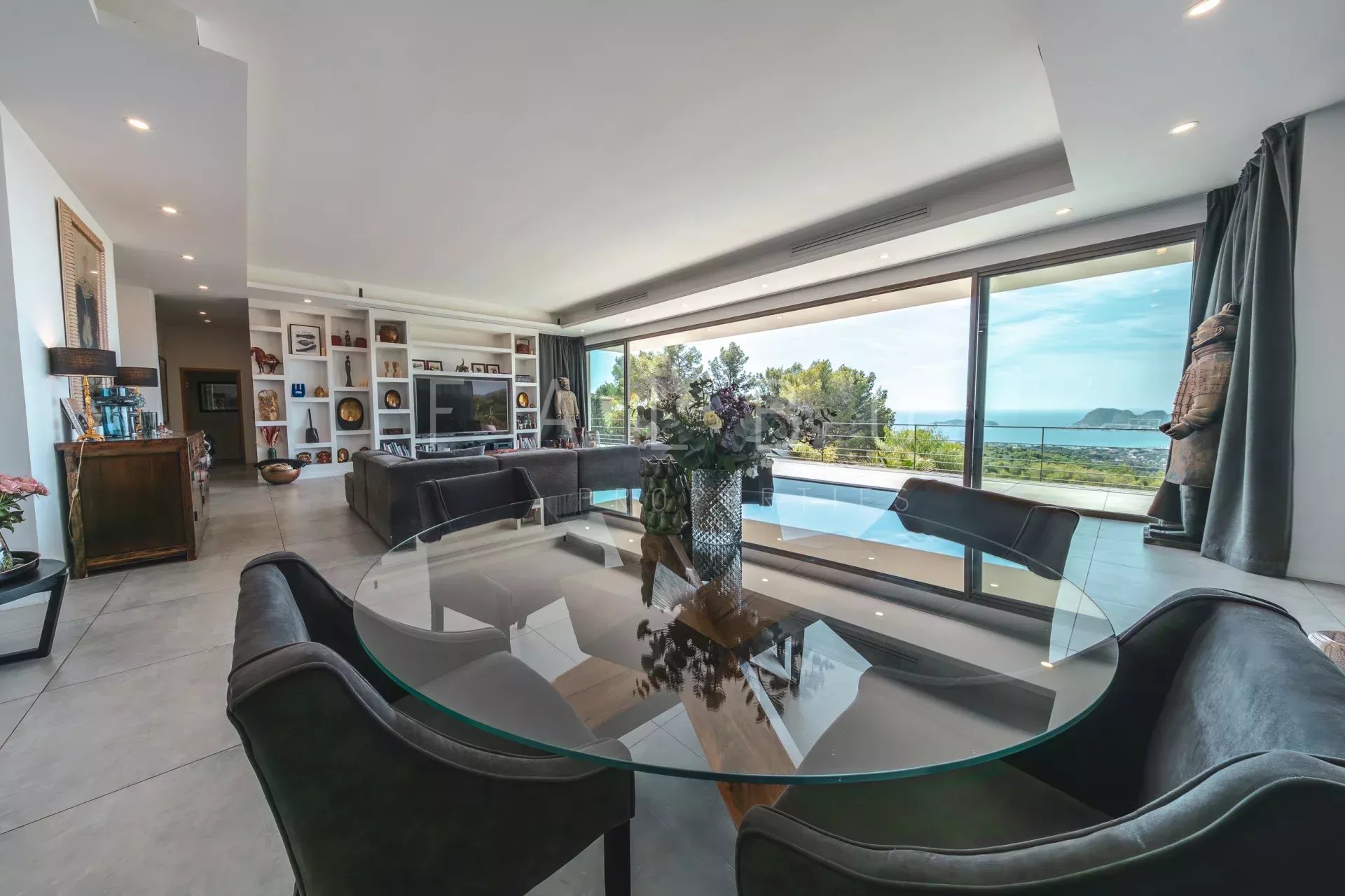 Intérieur d’une villa à Ceyreste Intérieur d'une villa contemporaine avec vue sur la mer, table ronde en verre et grandes baies vitrées.