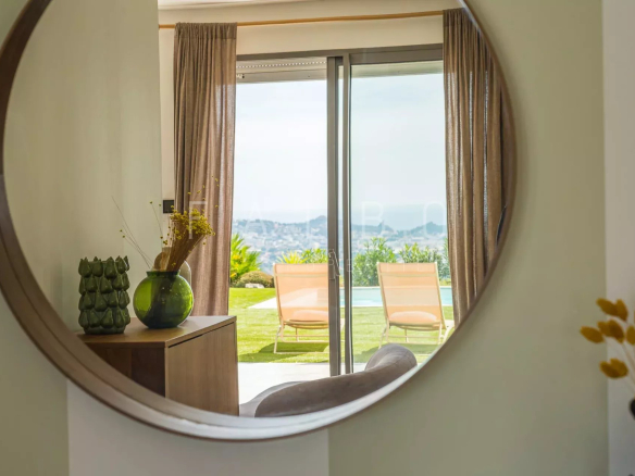 Intérieur d'une villa contemporaine avec vue sur la mer, à Ceyreste, à travers un miroir rond.