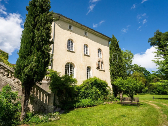 Château restauré avec jardin, situé à Anduze, ensoleillé sous un ciel bleu.