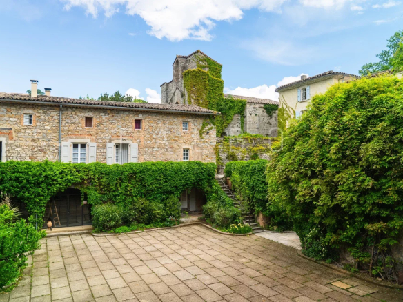 Château restauré avec une cour intérieure verdoyante, Anduze, France.