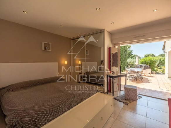 Chambre d'une villa contemporaine avec accès à une terrasse extérieure.