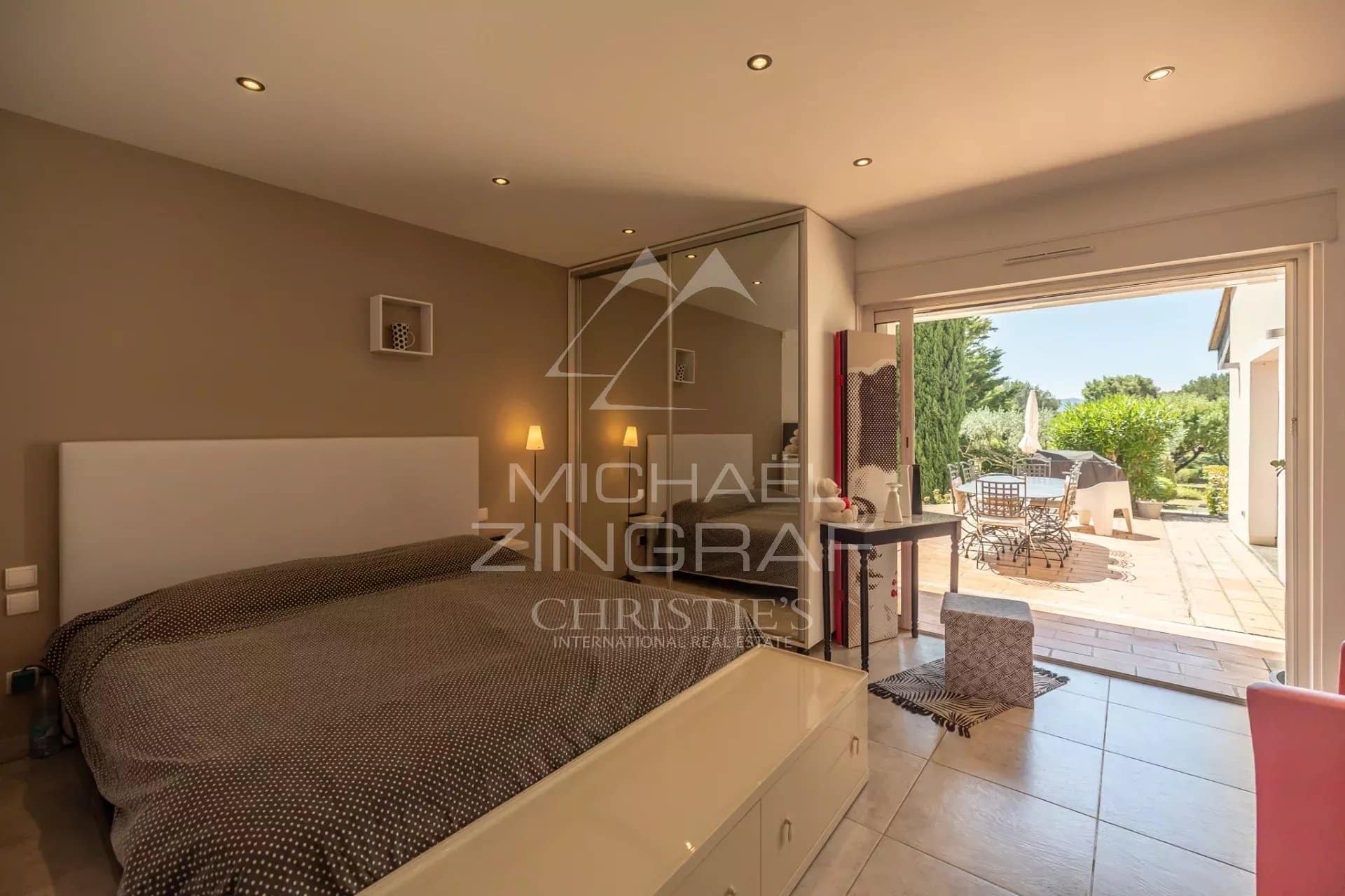 Chambre d'une villa contemporaine avec accès à une terrasse extérieure.