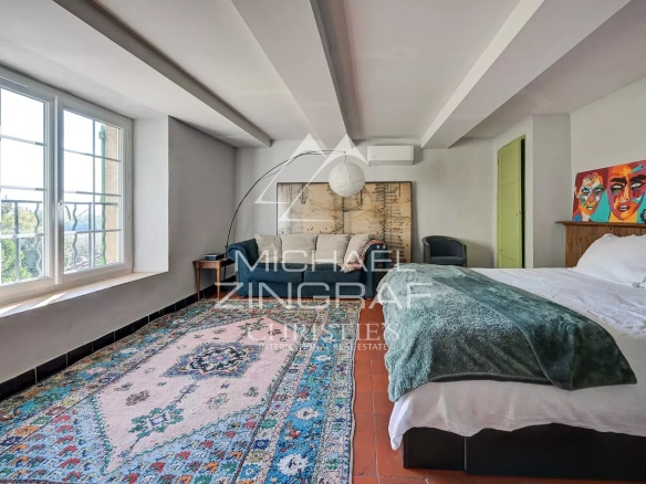 Chambre spacieuse avec lit double et décoration colorée.