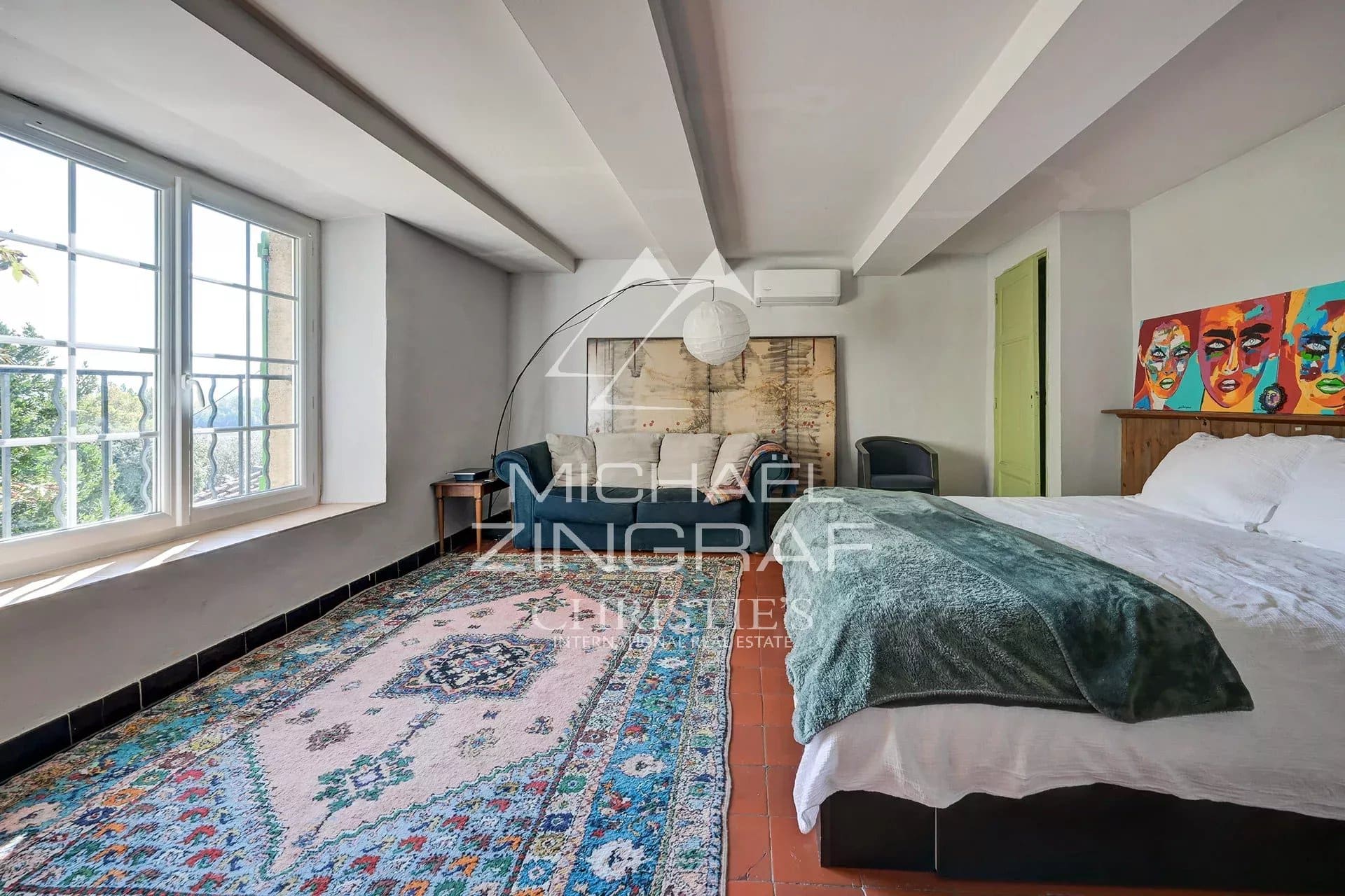 Chambre spacieuse avec lit double et décoration colorée.