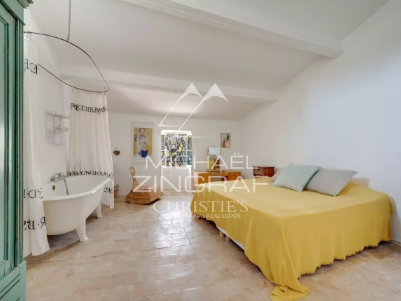 Chambre d'une demeure provençale du XIXe siècle avec baignoire et lit double.