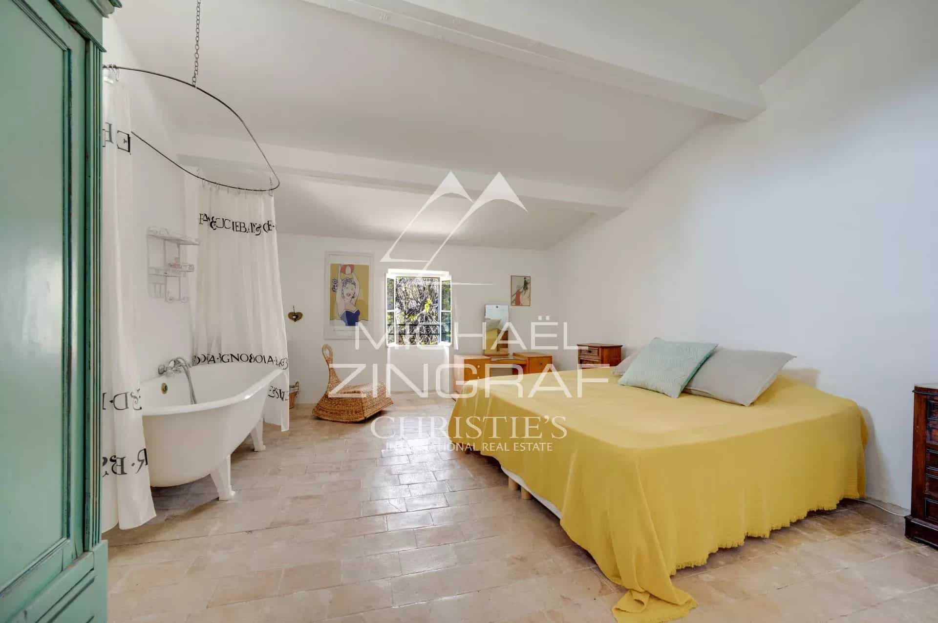 Chambre d'une demeure provençale du XIXe siècle avec baignoire et lit double.