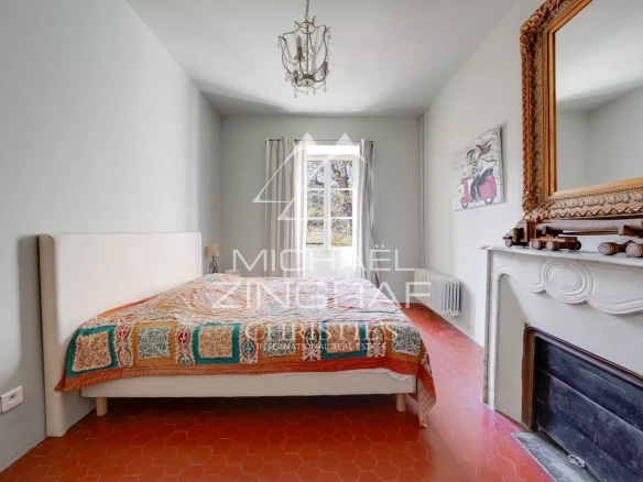 Chambre d'une demeure du XIXe siècle avec un lit et une cheminée.