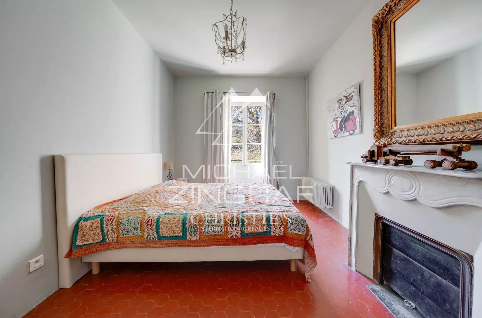 Chambre d'une demeure du XIXe siècle avec un lit et une cheminée.