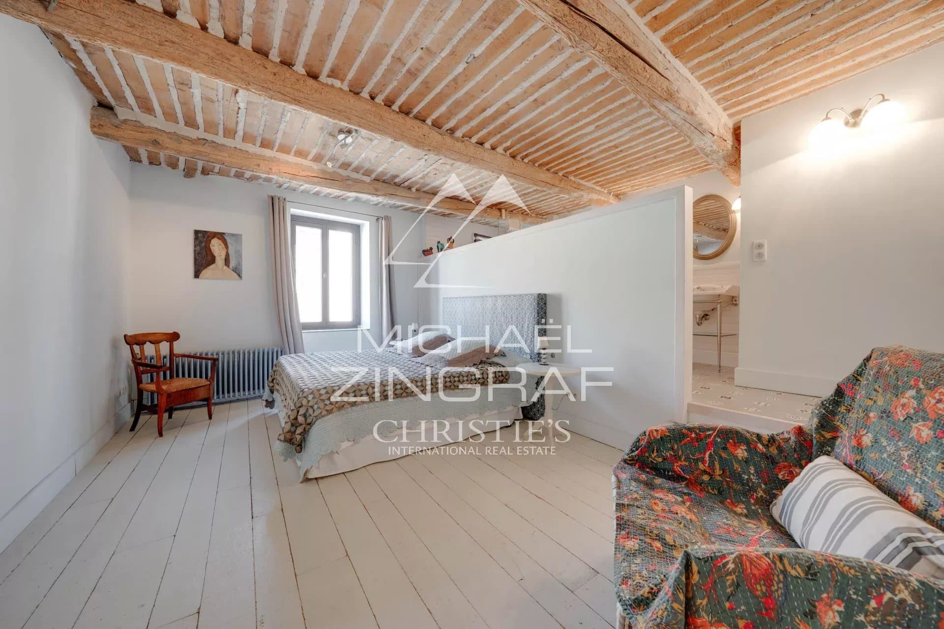 Chambre d'une maison du XIXe siècle avec poutres apparentes et mobilier ancien à Alleins, Provence.