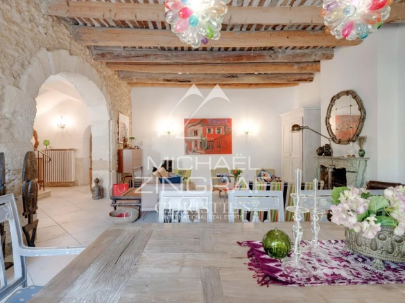 Intérieur d'une demeure provençale du XIXe siècle avec des poutres apparentes et une décoration élégante.