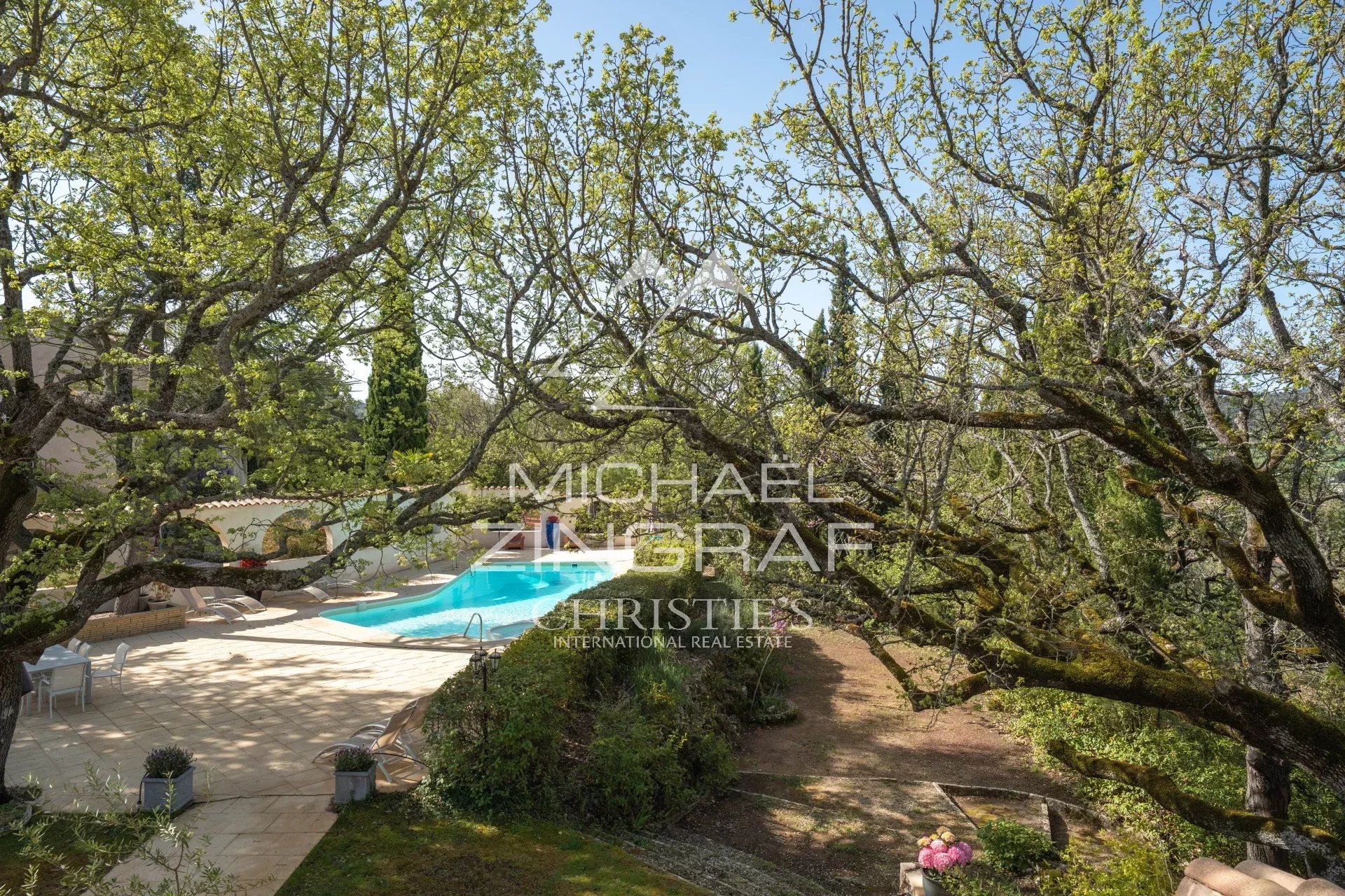 View of the estate with swimming pool surrounded by trees in Rians, Provence.