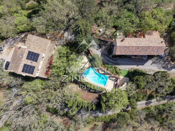 Aerial view of an estate with swimming pool and buildings in a wooded area in Rians.