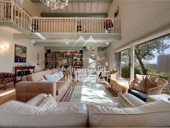 Interior of a Provençal estate with a spacious living room and mezzanine, bathed in light.