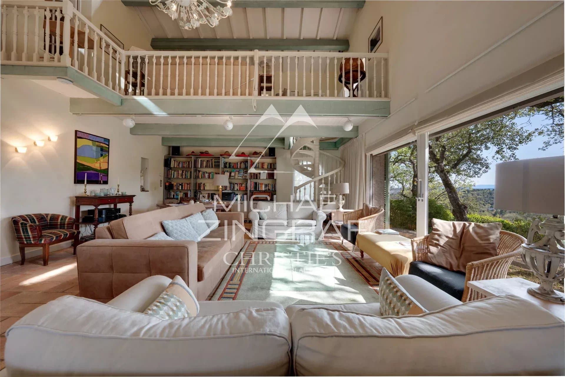 Interior of a Provençal estate with a spacious living room and mezzanine, bathed in light.