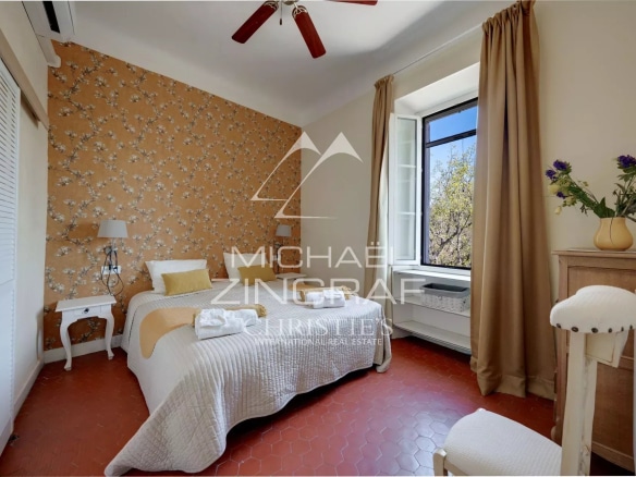 Room in a Provençal estate with vintage decor and a window overlooking the outside.
