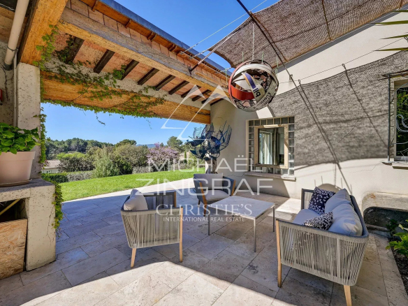 Terrace of a bright property in Mérindol with outdoor furniture and views of nature.