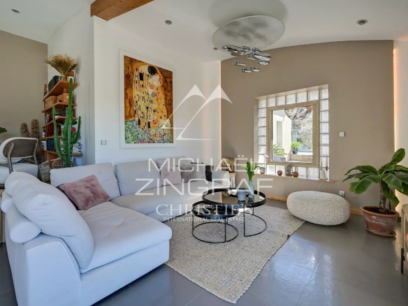 Interior of a bright house with a modern living room and natural decorative elements.