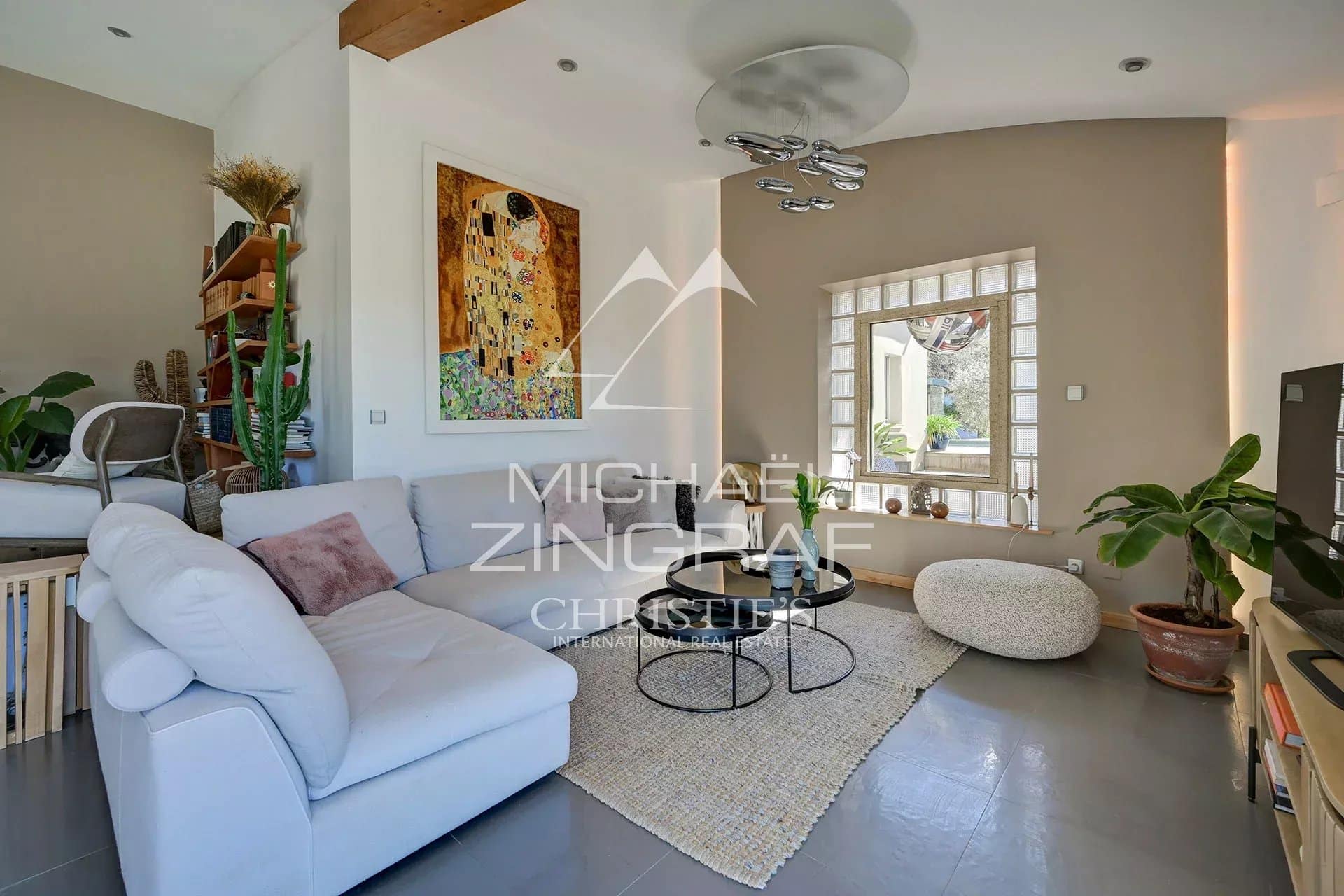 Interior of a bright house with a modern living room and natural decorative elements.
