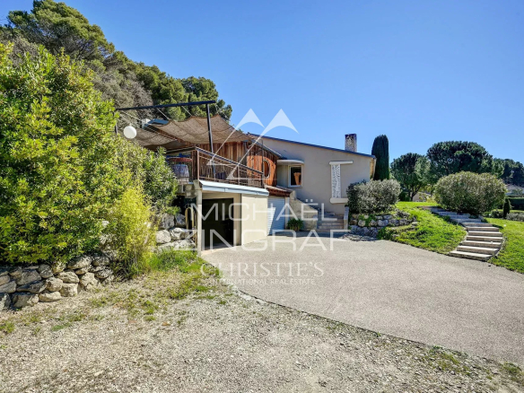 Single-storey house surrounded by greenery in Mérindol, with a terrace and access path.